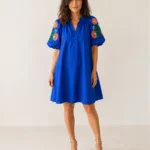 Robe courte bleu roi à manches bouffantes et broderies florales portée de face