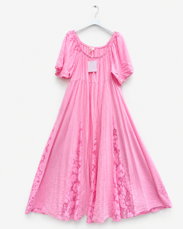 Robe longue rose fluide pour femme avec manches courtes bouffantes, empiècements en dentelle florale et étiquette visible, présentée sur cintre.