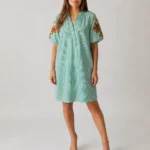 Robe courte rayée verte et blanche à manches bouffantes brodées portée par un mannequin