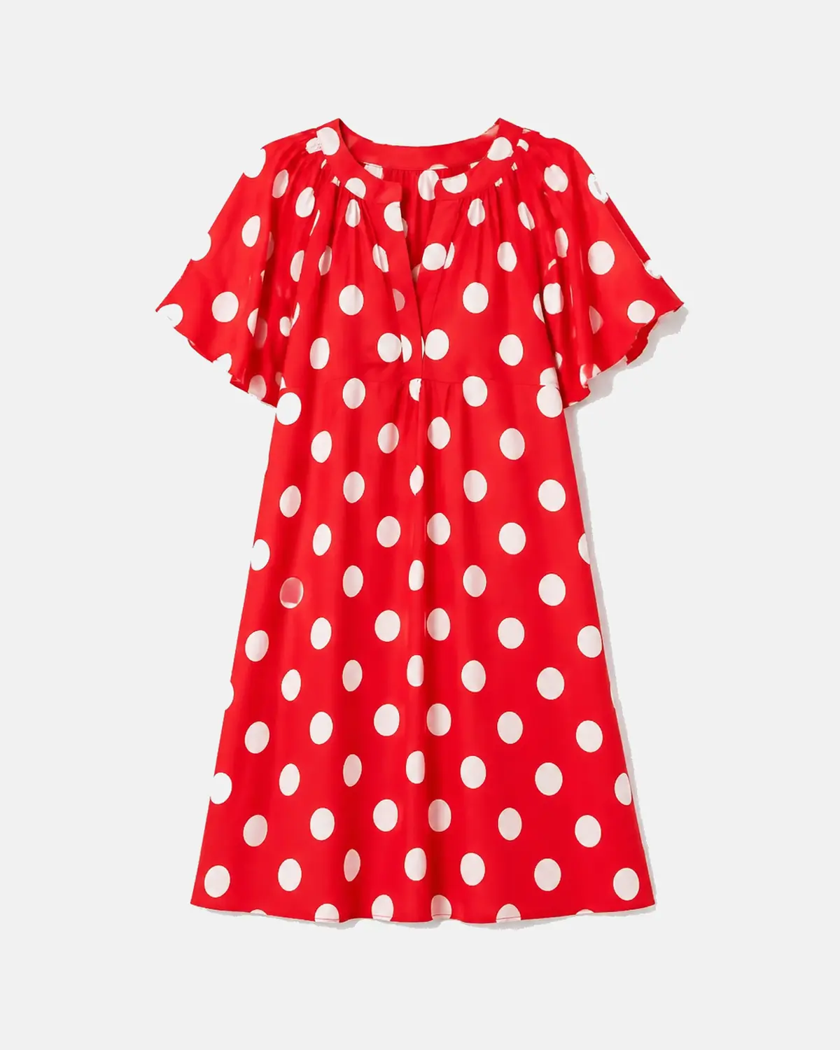 Robe rouge à pois blancs pour femme posée au mur sans cintre, vue de face